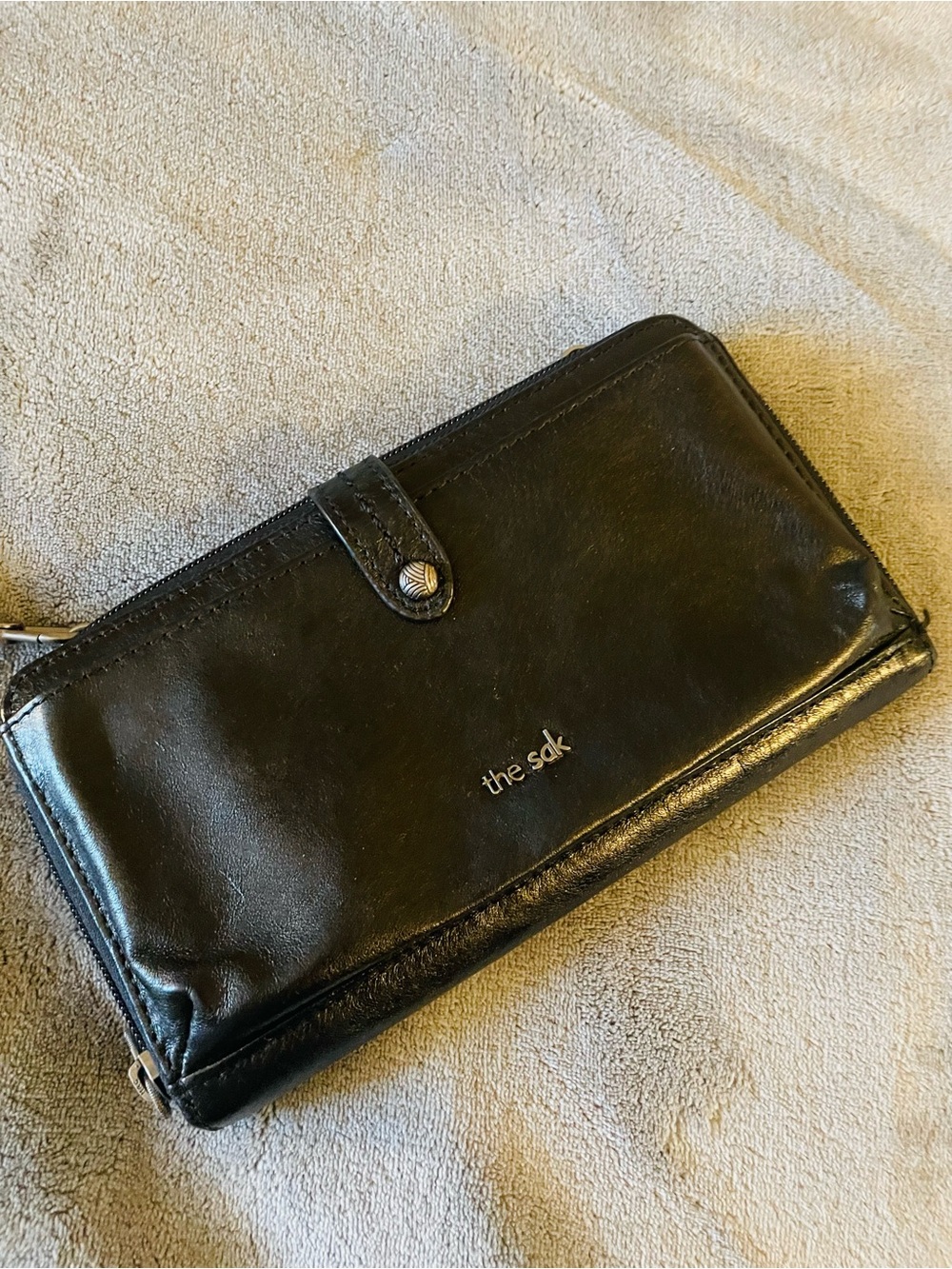 The Sak black leather zip wallet with snap tab
